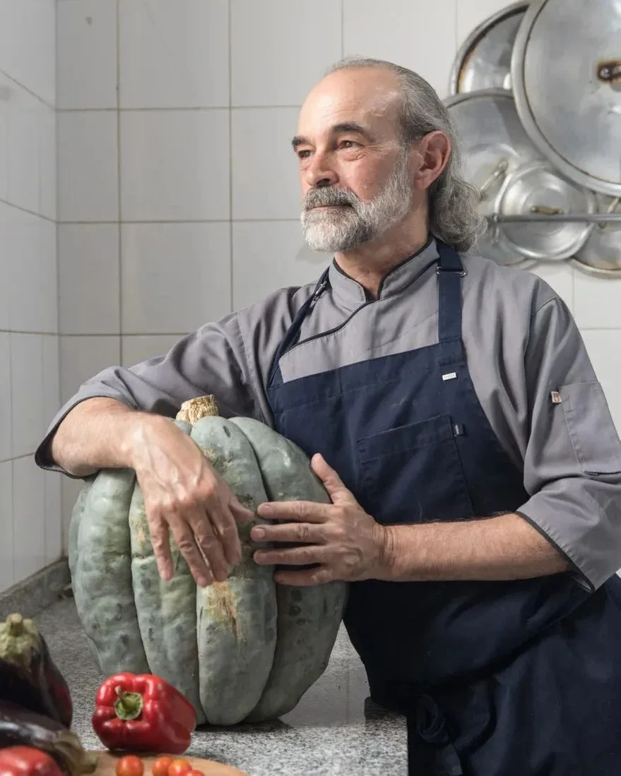 El chef de Calandria en la cocina, apoyado sobre un zapallo