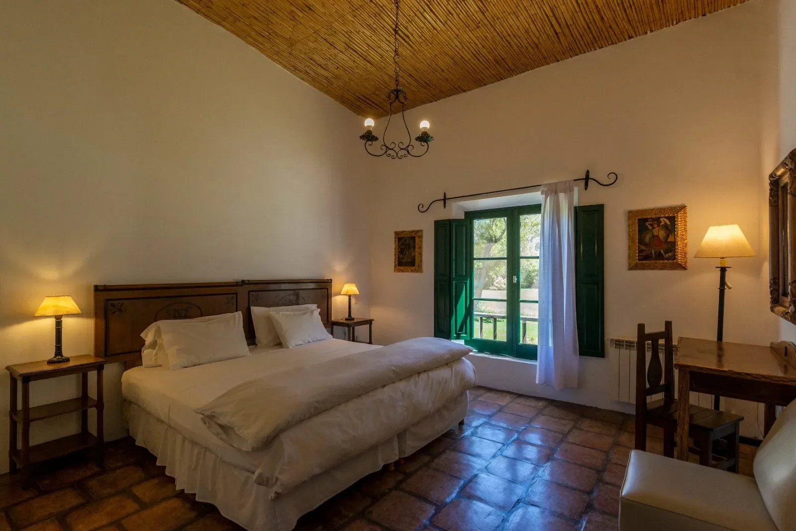 Habitación con cama king, veladores encendidos y techo de madera
